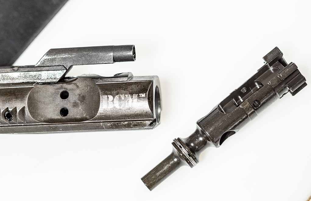 The extractor sits at the 10 o’clock position on the bolt (shown here removed). It has a lug on the outside, and a round claw on the inside that completes the circular bolt face.