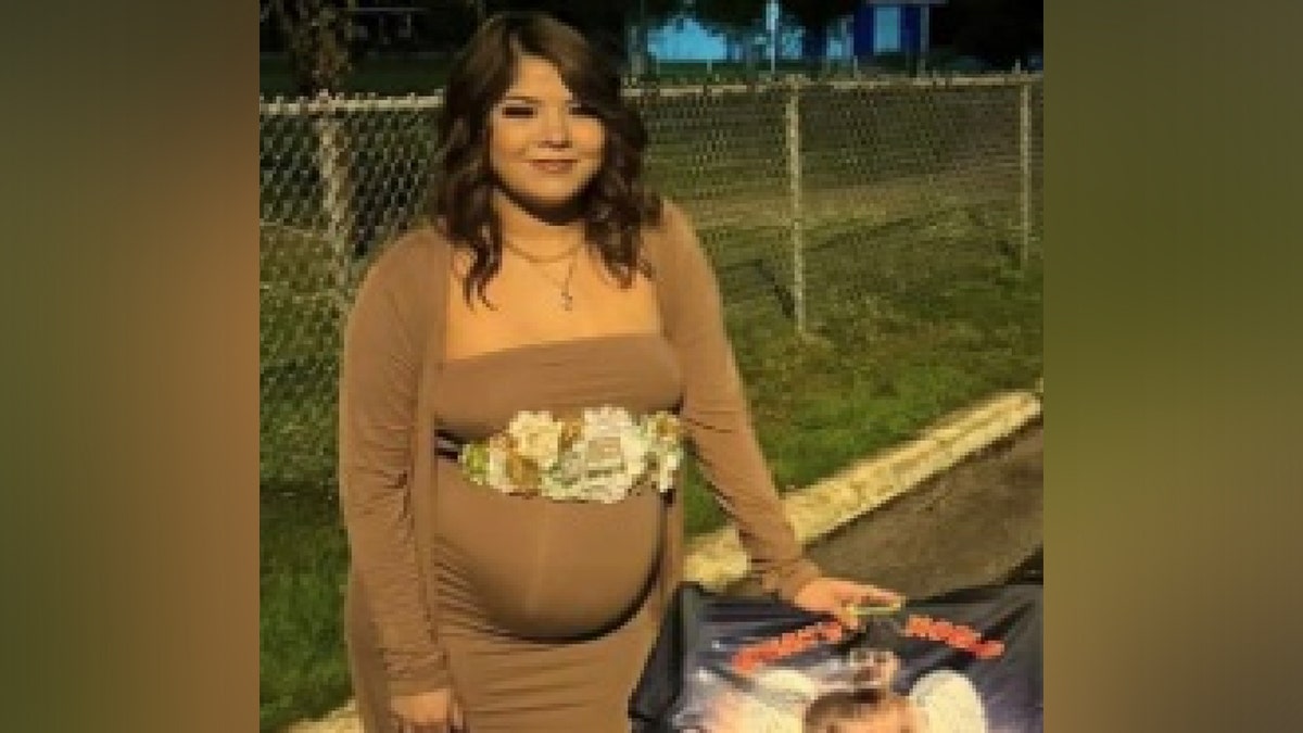A pregnant Soto poses in a brown dress