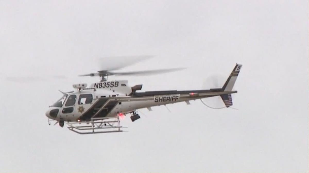 A police helicopter flies over the scene of a mass shooting