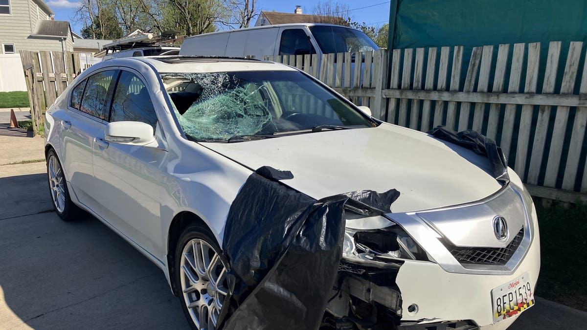 White Acura with damage to hood and windshield. 