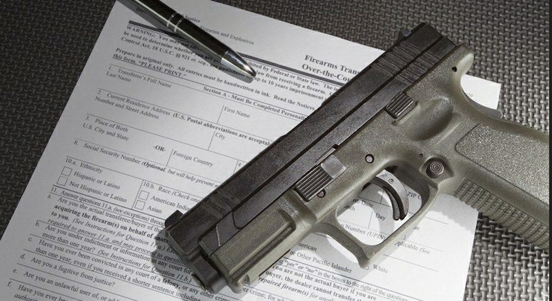 Pistol lying on a federal background check form