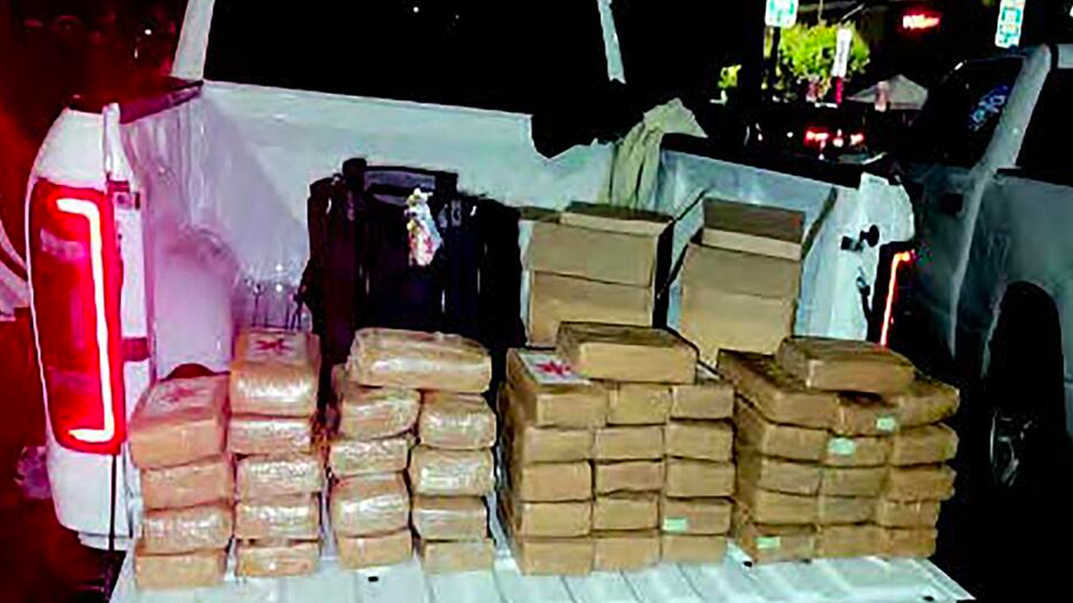 U.S. District Attorney shows confiscated drugs piled up in a truck bed