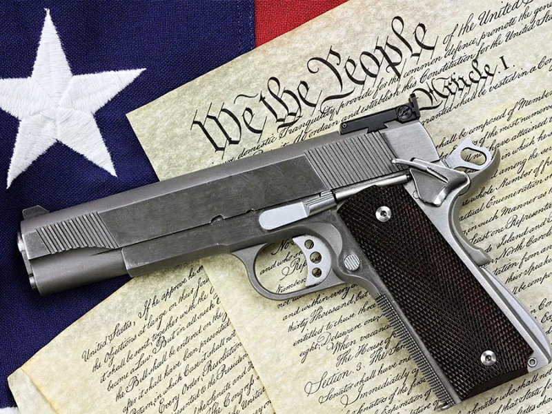 A pistol lying on the US Constitution