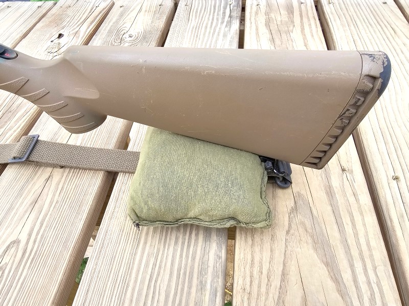 Lightweight sandbag supporting a rifle stock.