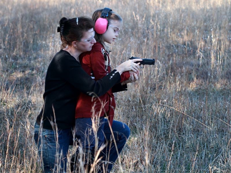 Teaching a child to shoot.