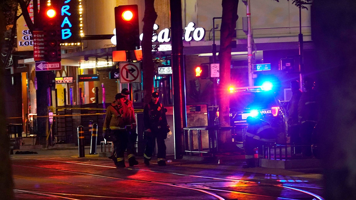 Emergency personnel walk near the scene of an apparent mass shooting in Sacramento, Calif., Sunday, April 3, 2022.