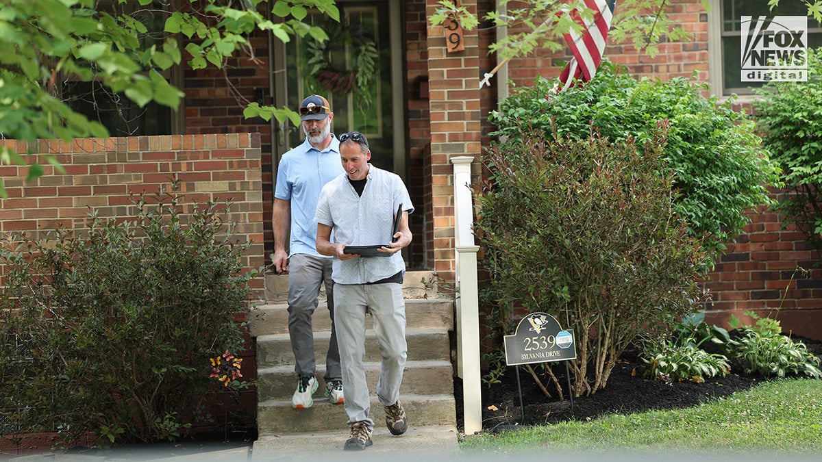 Two men leaving a home.