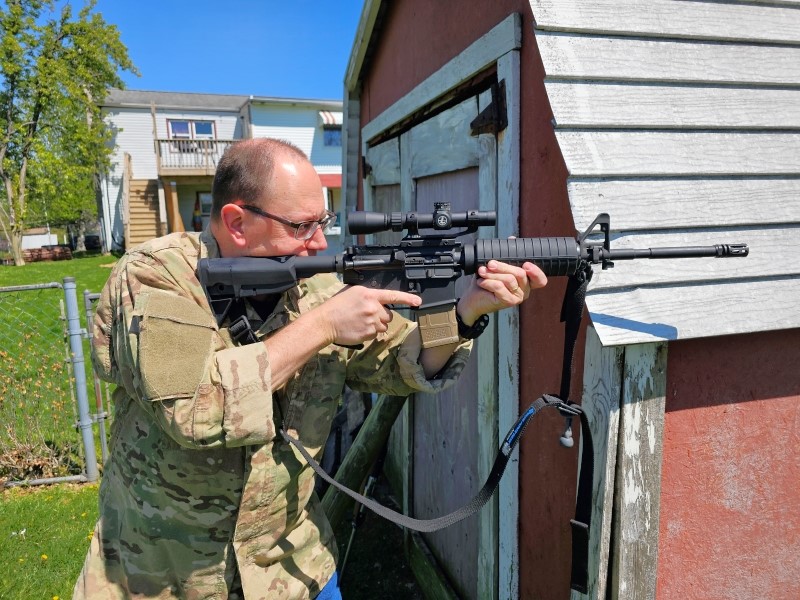 AR carbine near a building.