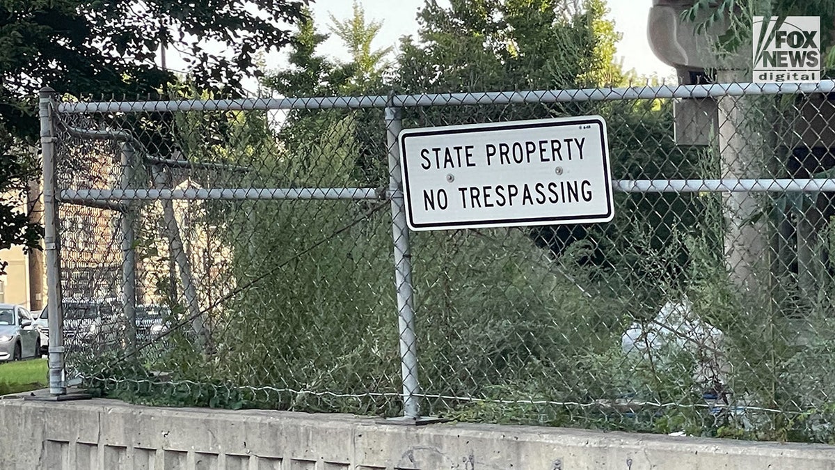 Sign that reads "No Trespassing" on fence