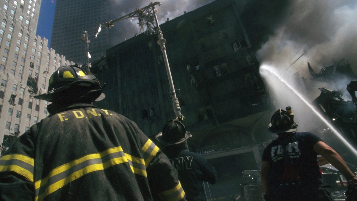 Colour photograph of a New York Fire-fighter amid the rubble of the World Trade Centre following the 9/11 attacks. 