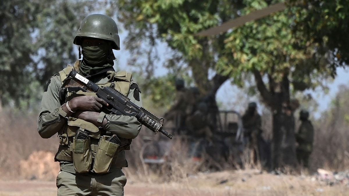 An Ivorian soldier provides security on arrival of Ivorian Prime Minister Patrick Achi at the launch of a vast aid plan for young people in regions bordering Mali and Burkina Faso where jihadist groups are trying to recruit, in Tougbo, on January 22, 2022. (Photo by Sia KAMBOU / AFP) (Photo by SIA KAMBOU/AFP via Getty Images)