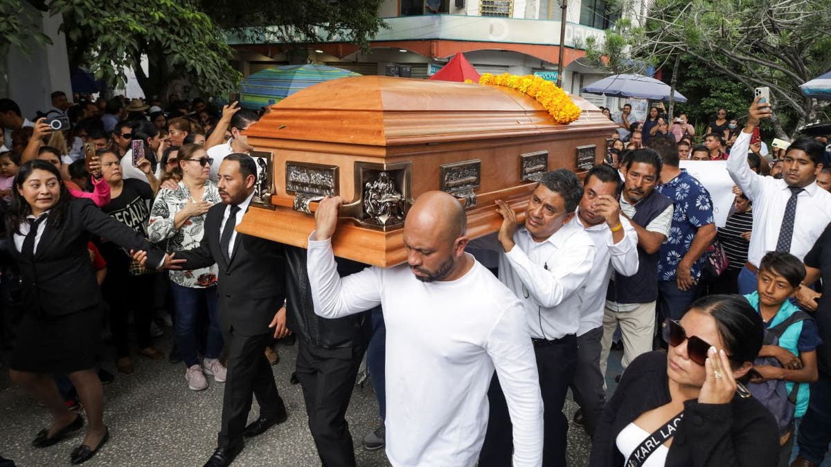 Pallbearers carrying Arcos casket