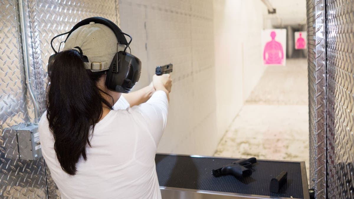 Woman shooting gun at range