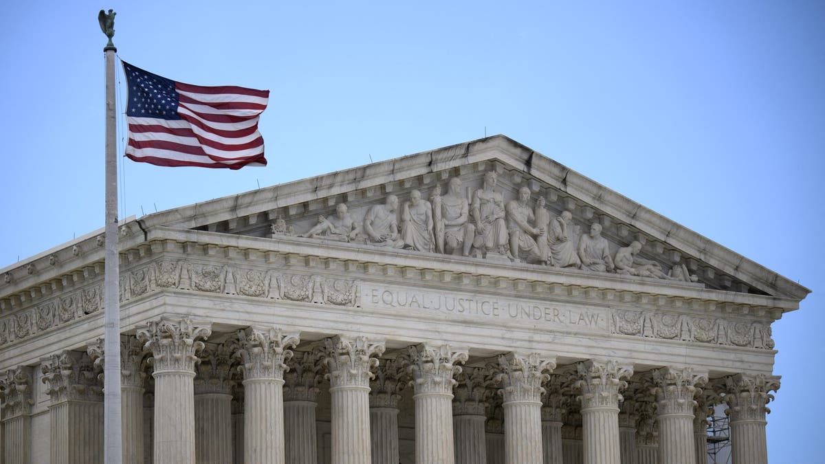 A US flag waves in front of the Supreme Court building in DC