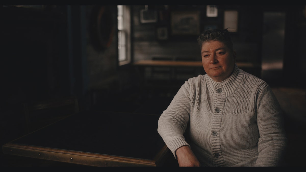 A woman in an ivory sweater speaking out about the Lady of the Dunes.