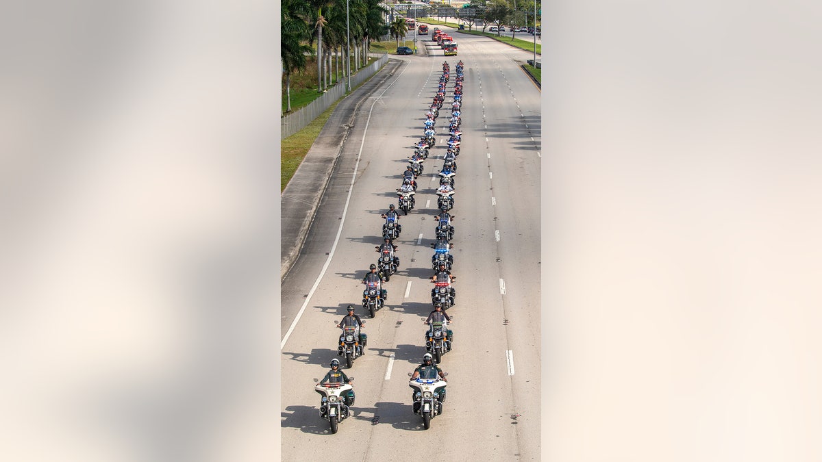 Rescue vehicles carry the two Palm Beach County Sheriff's Office deputies from the motorcycle unit who were struck and killed by a vehicle