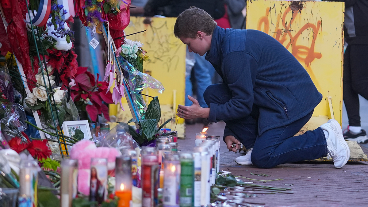 Nathan Williams, a University of New Orleans student, lights a candle at memorial on Bourbon Street