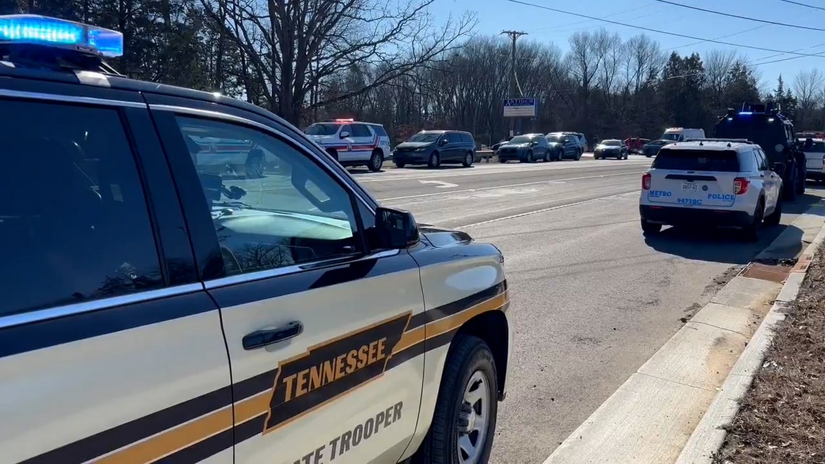 Police cars line the street outside of Antioch High School.