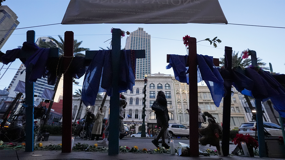 People walk past a memorial on Canal Street