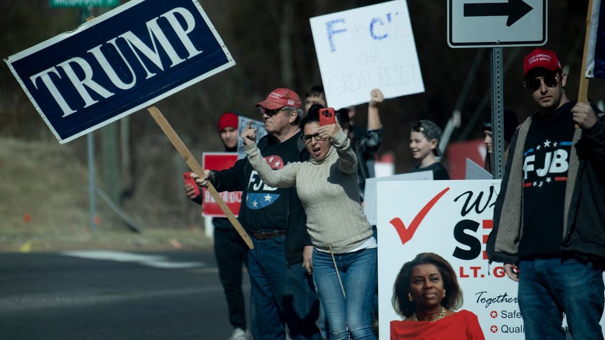 Protesters greet a motorcade with President Joe Biden Feb. 10, 2022, in Culpeper, Va.
