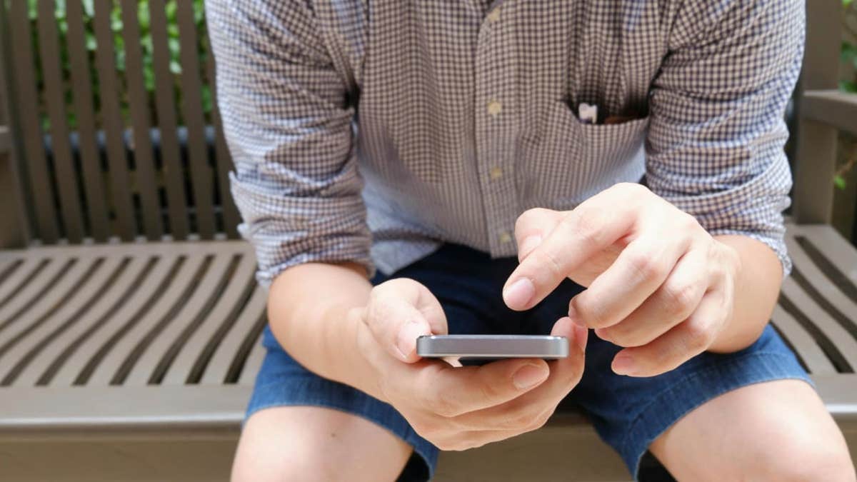 man scrolling smartphone