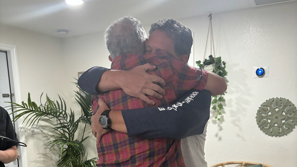 Gilbert King hugging Leo Schofield