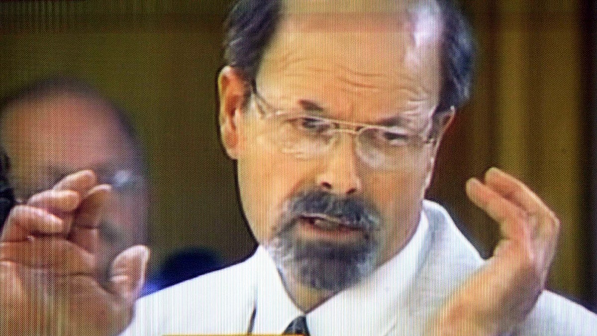 A close-up of Dennis Rader wearing a white suit and explaining his crimes in court.