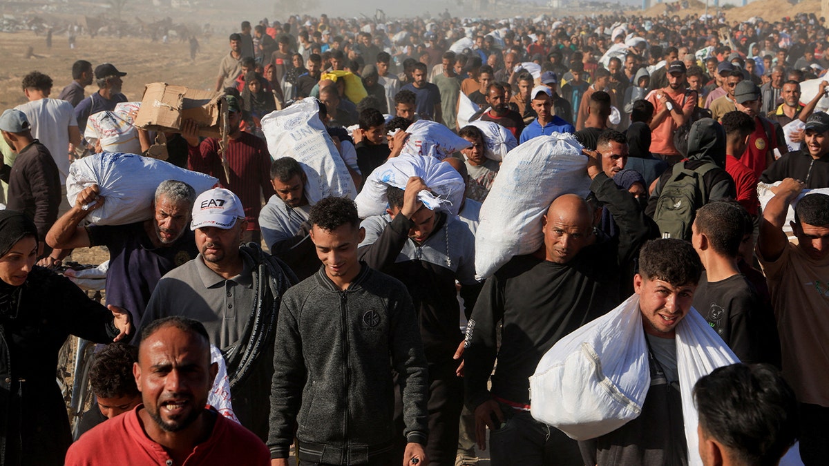 Palestinians carry aid from the Gaza Humanitarian Foundation