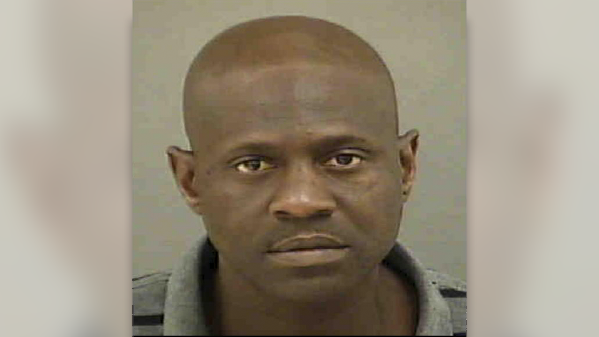 Bennett wearing a gray golf shirt, with clean shave and bald head