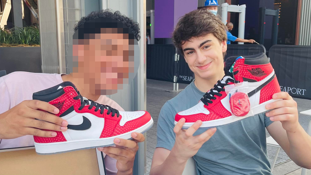 Two young men hold up red and white Nike sneakers, the one on the right is Milo Sedarat, who has been named as a suspect in a federal terror plot case
