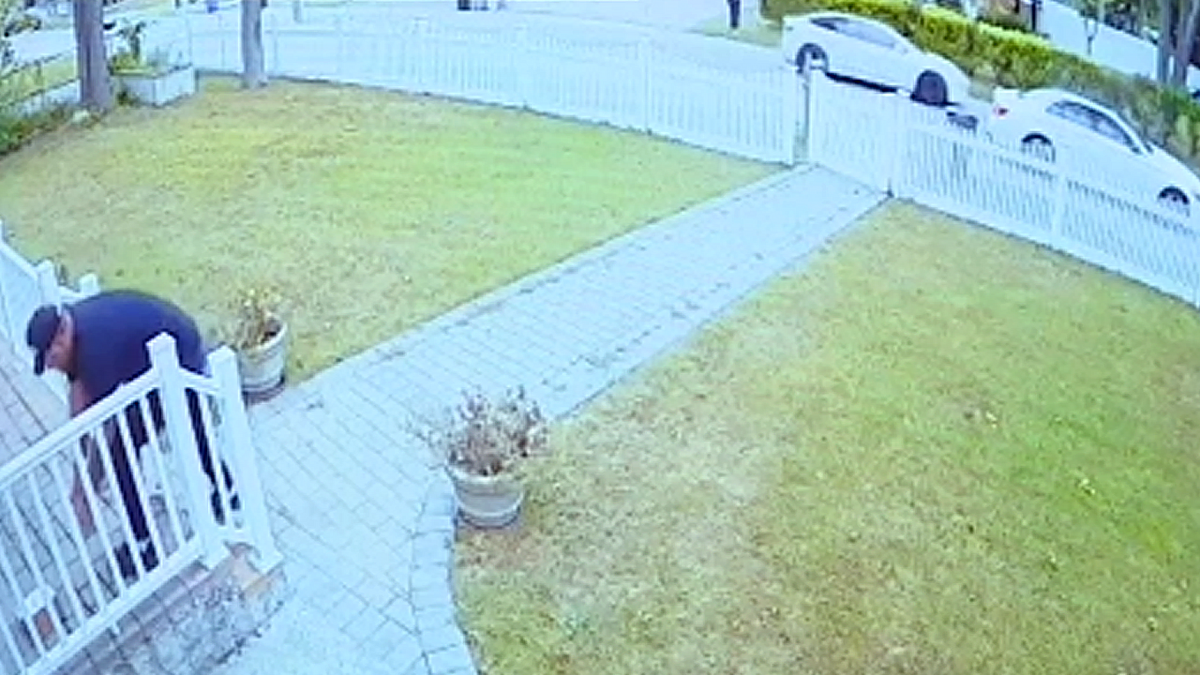 A man pictured taking a package off of a front porch on Long Island