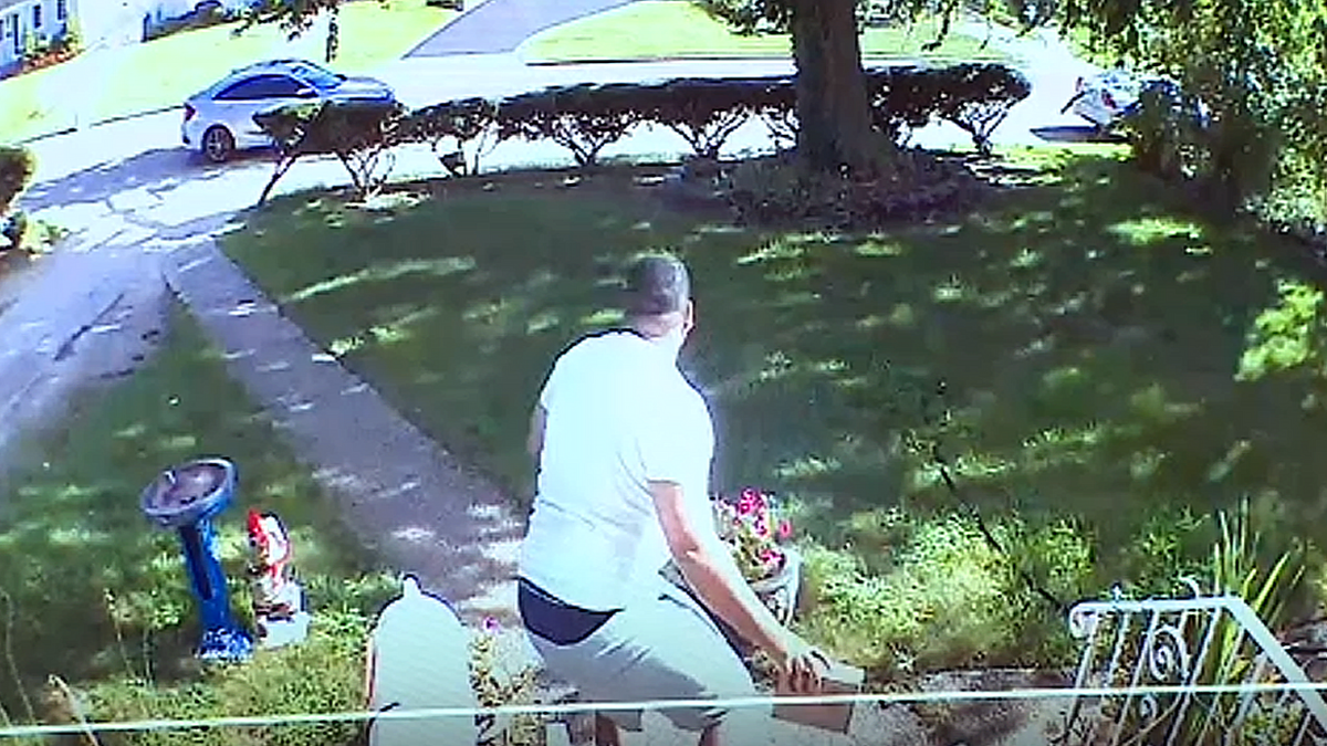 A man pictured taking a package off of a front porch on Long Island