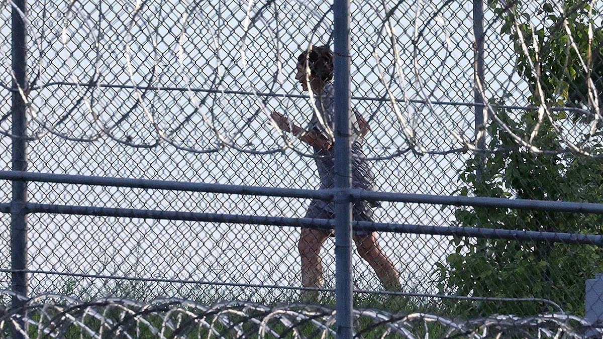 Ghislaine Maxwell is seen behind razor wire in prison