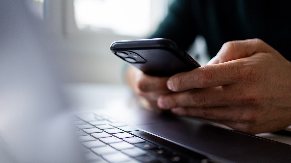 Man's hands holding a smart phone