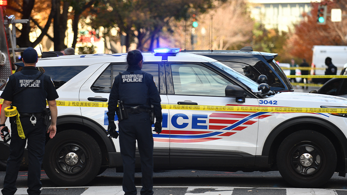 Police standing outside patrol vehicle in DC