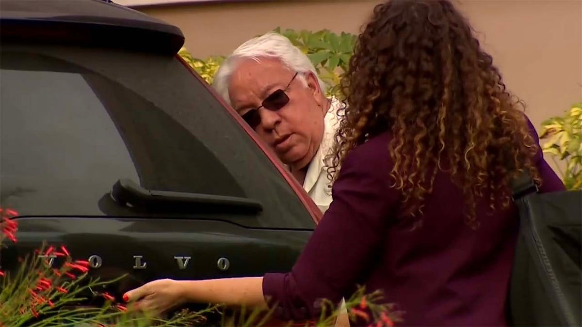Carlos Guillermo Alonso exits a vehicle with his attorney.
