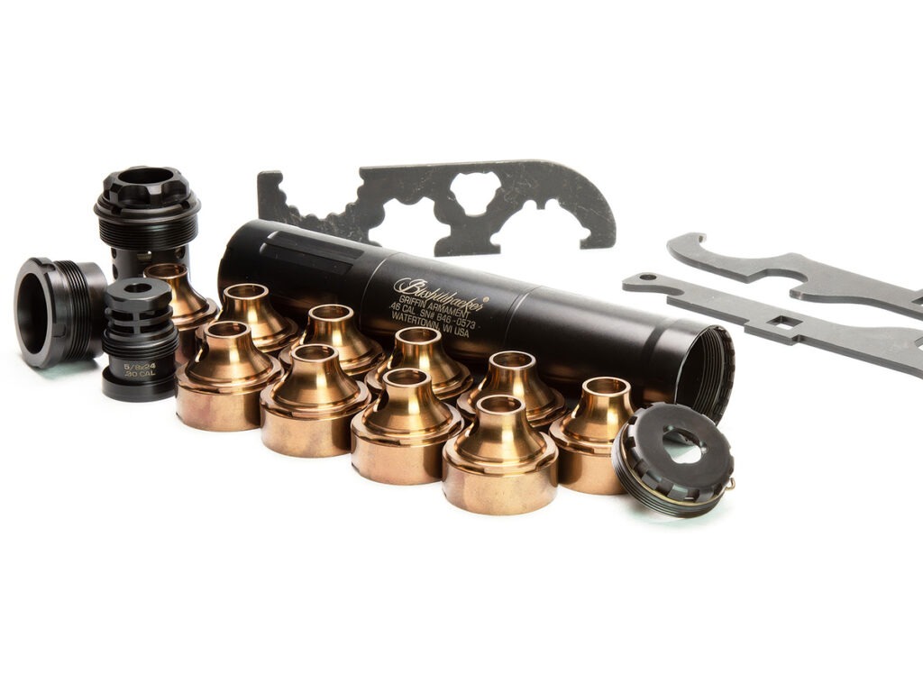 A Griffin Armament suppressor disassembled with its baffles, muzzle device mounts and tools sitting next to it.