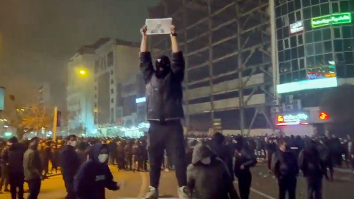 Protester holding sign in Tehran on Friday